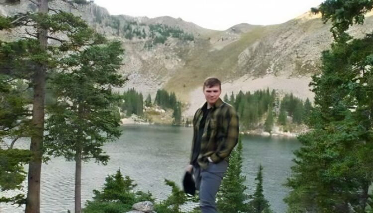 Garrison standing by a lake in the mountains – Via Merril and Janelle – Instagram