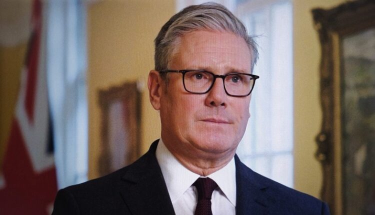 Keir,Starmer,,Wearing,Glasses,And,A,Suit,,Looks,Directly,At